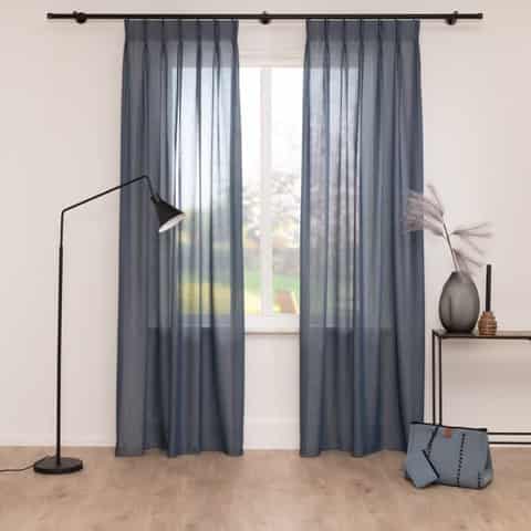 Denimblauwe transparante gordijnen in een licht interieur